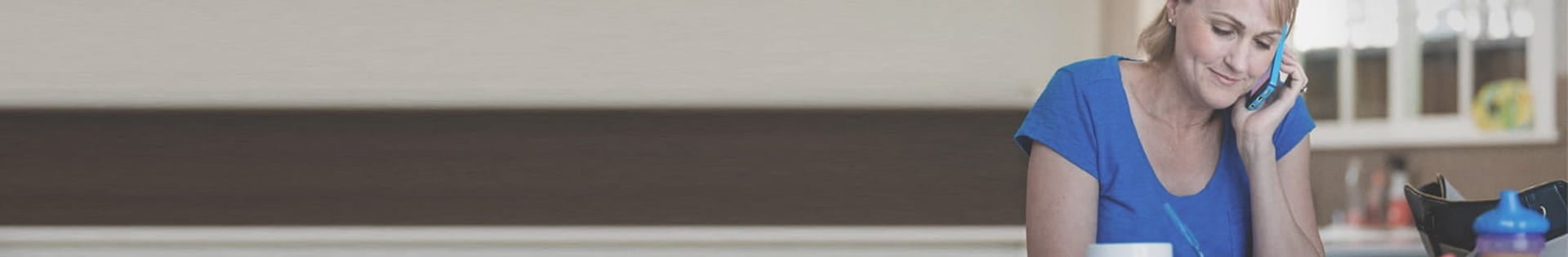 female_with_phone_writing_on_kitchen_counter