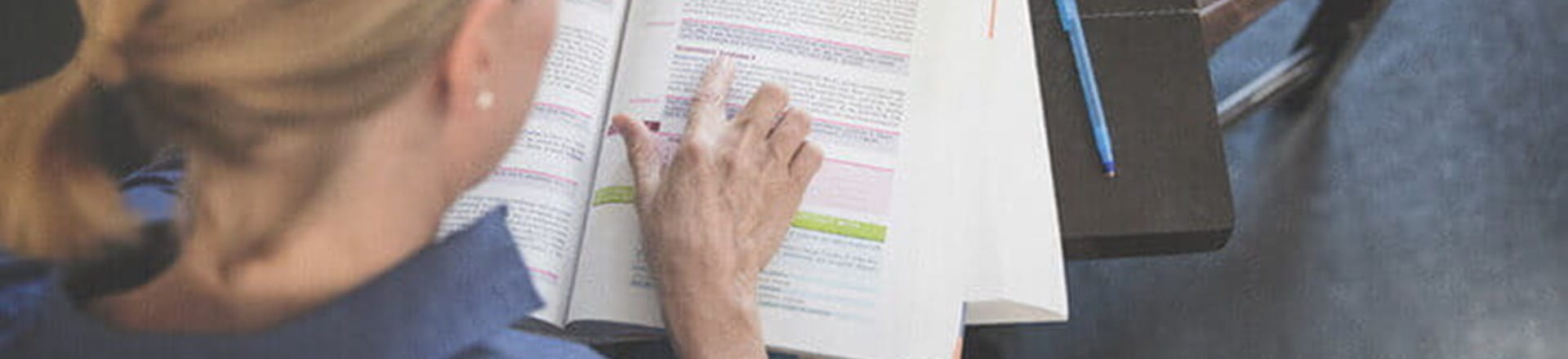 female_studying_with_textbook_at_lunch_table