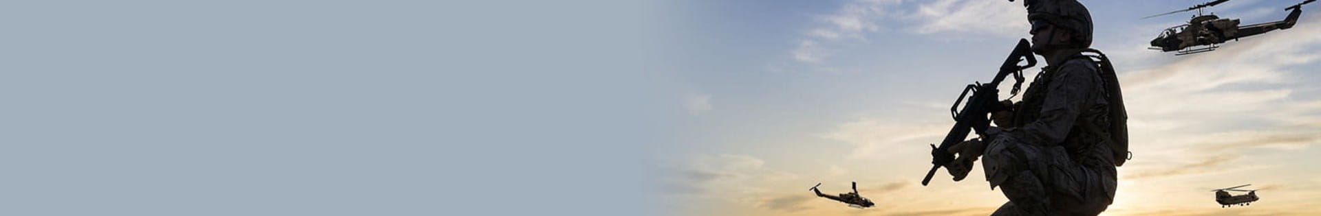 military man holding a gun with helicopters hovering in the sky