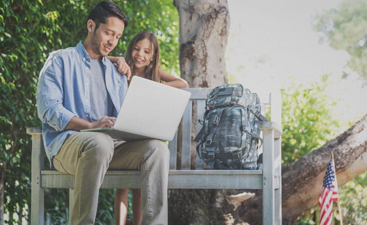 military_father_with_daughter_using_laptop_outside_daylight