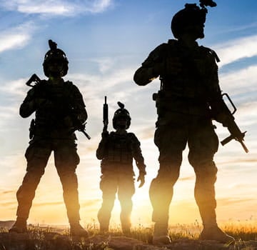 three military men in uniform standing outside 