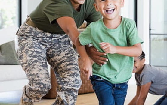 military mother and son laughing while running and playing