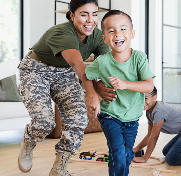 military mother and son laughing while running and playing