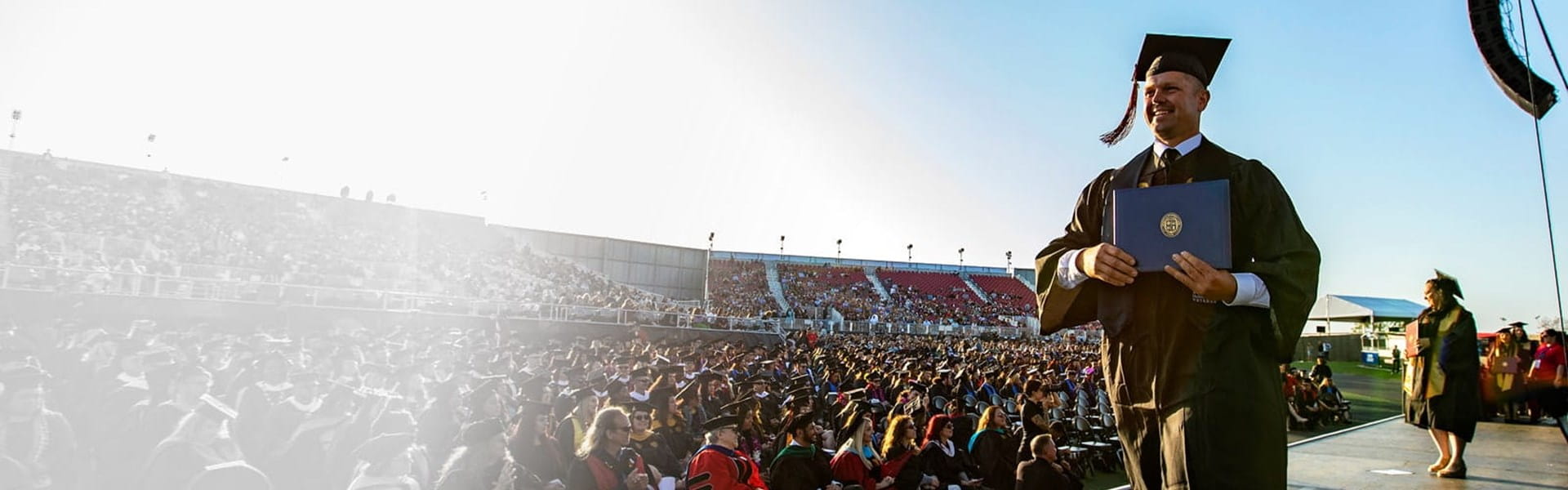 A student walking across the stage at commencement.