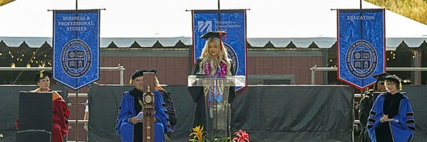 Nursing student giving commencement speech on stage at UMass Global Commencement