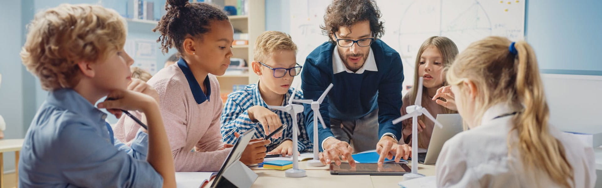 male teacher working with elementary kids on a science project