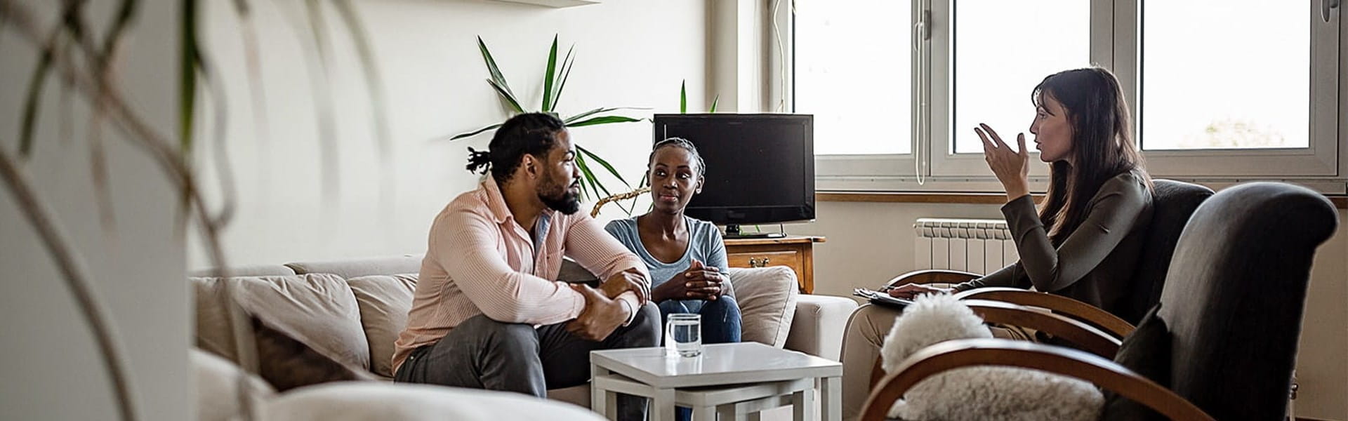 female psychologist talking to married couple in counseling session