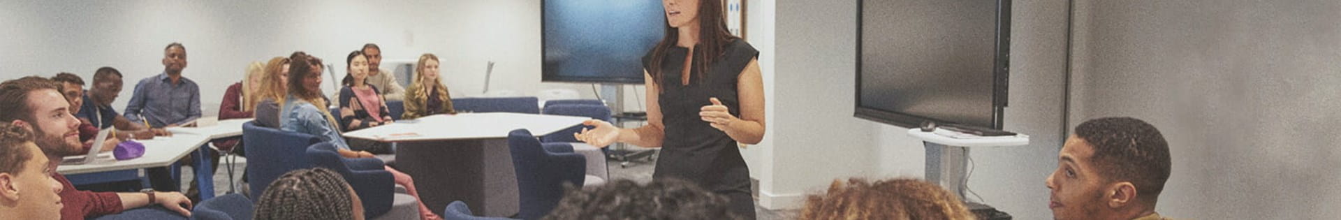 female teacher lecturing students about teaching curriculum in classroom