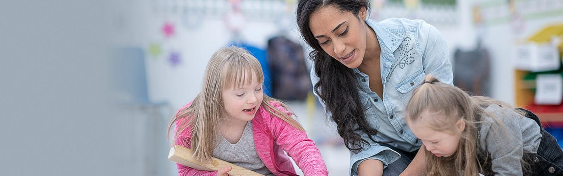 female special education teacher observing two playing female children