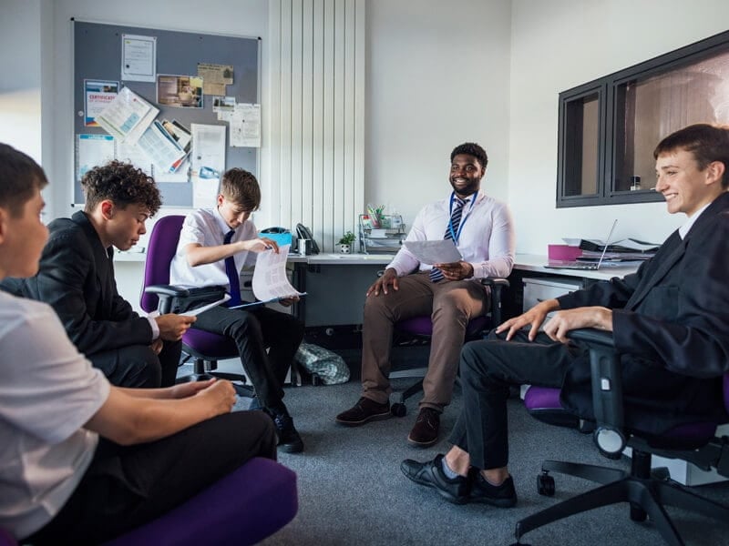 male school counselor working with a group of middle school boys