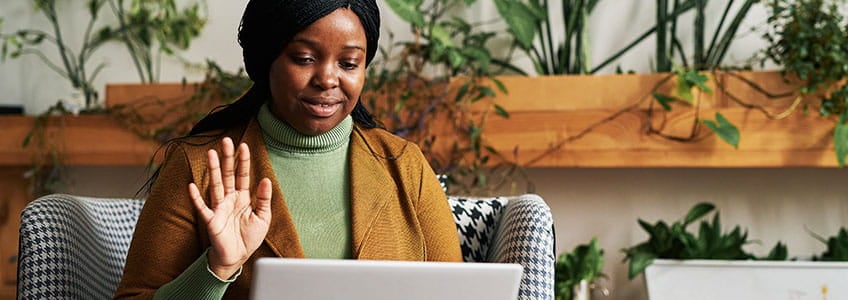 A woman student is sitting at her computer for a virtual counseling session.