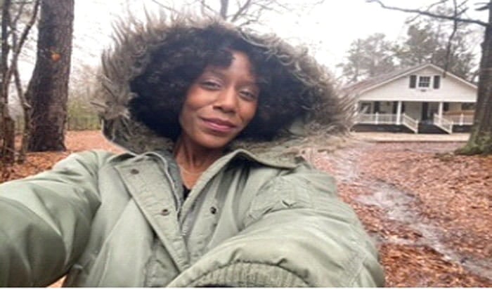 A "selfie" of former UMass Global administrative assistant Autumn Farmer with a house in the background.