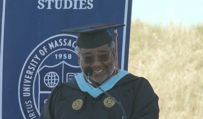 Northern California Commencement speaker David Earl Cobb IV delivering his speech wearing graduation regalia.