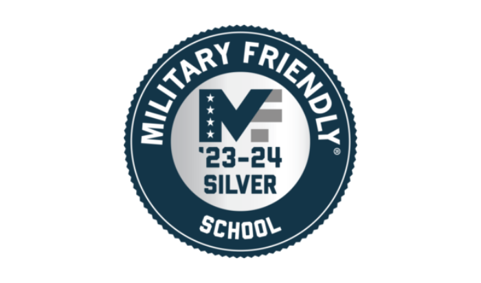 A silver-and-blue badge with the phrases "Military Friendly School" within the outer blue ring and "'23-24 Silver" under a logo combining the letters "M" and "F" with American flag-inspired stars and stripes in the silver center.