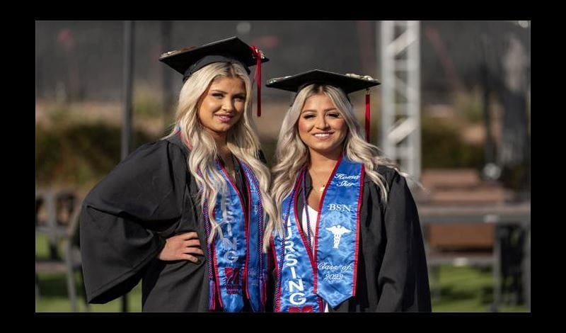 Class of 2022 nursing graduates Sonia and Homa Sher standing next to each other wearing their regalia.