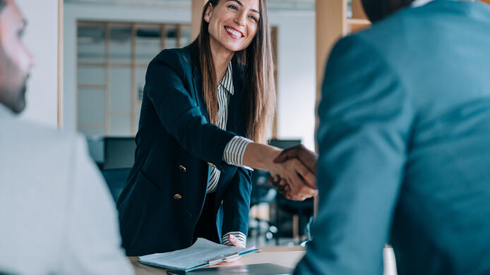 Business people shaking hands in the office. Group of business persons in business meeting. Three entrepreneurs on meeting in board room. Corporate business team on meeting in modern office. Female manager discussing new project with her colleagues. Company owner on a meeting with two of her employees in her office.