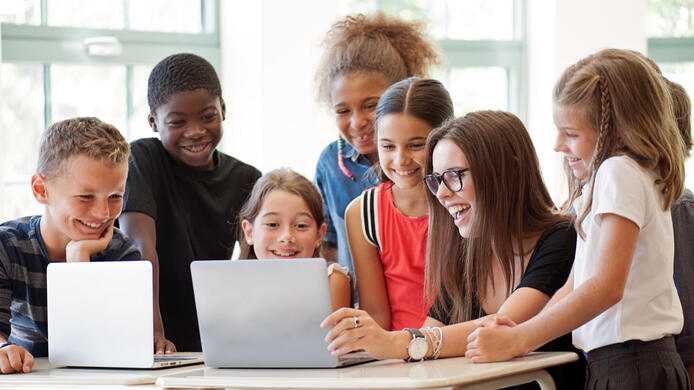 Elementary teacher with students on laptop