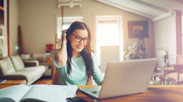 female student with laptop studying at home