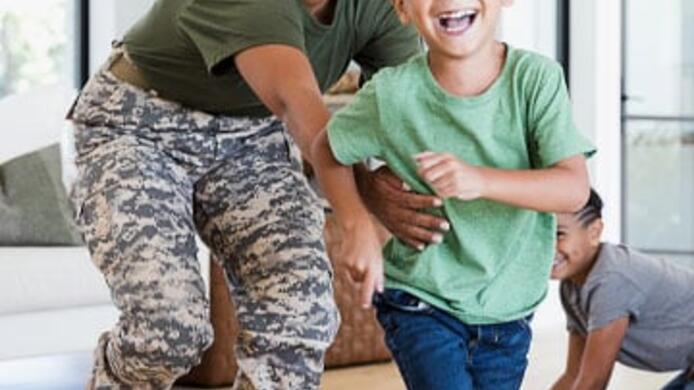 military mother and son laughing while running and playing