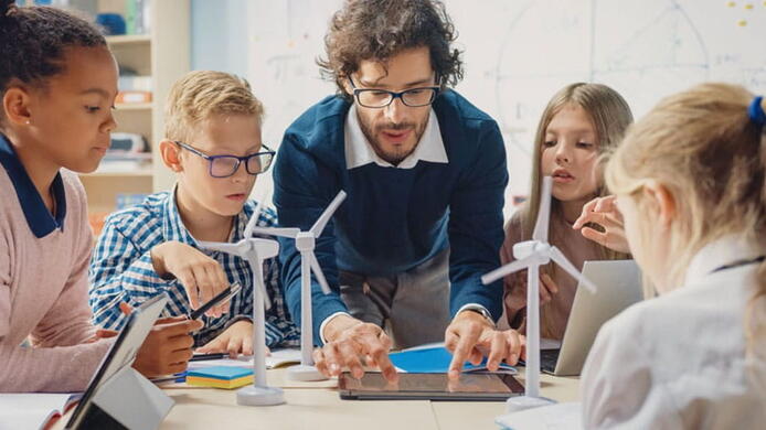 male teacher working with elementary kids on a science project