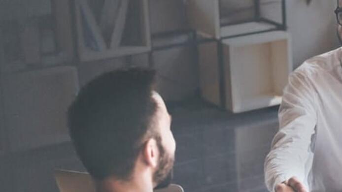 couple talking to male finance professional and shaking his hand