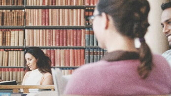 international business students studying together at table in library