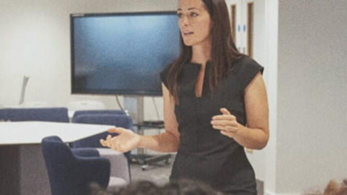 female teacher lecturing students about teaching curriculum in classroom