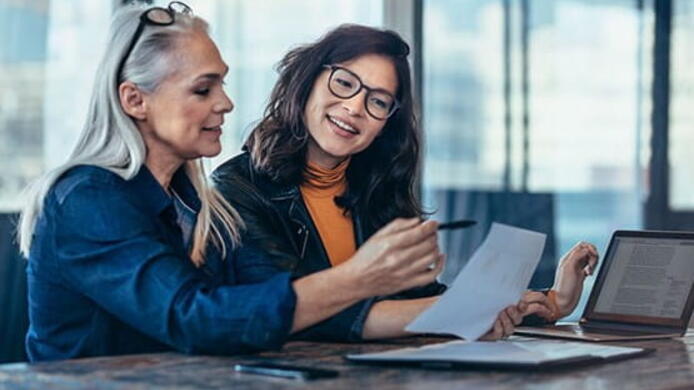 older female business women mentoring younger asian female at informal location