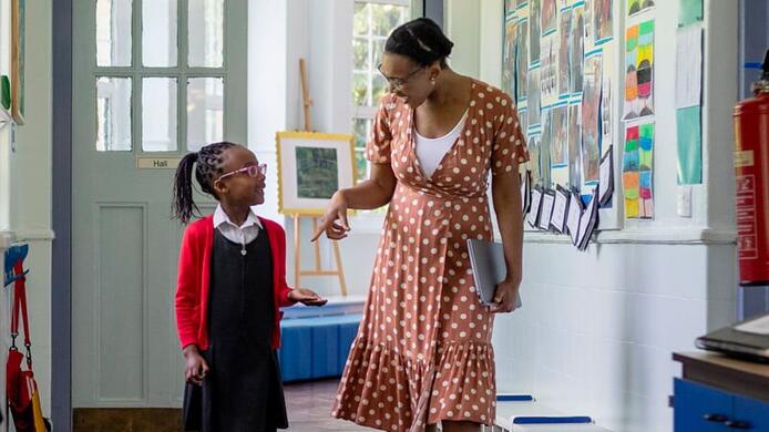 a school counselor talking to a girl student while walking