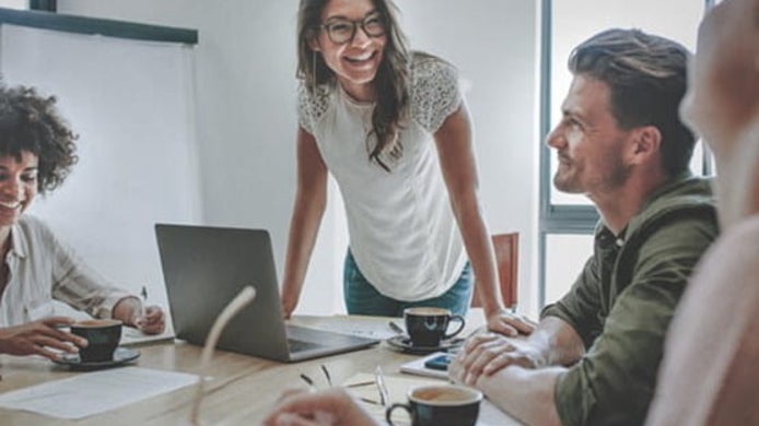 group of sociology students talking with one another at a table in a classroom