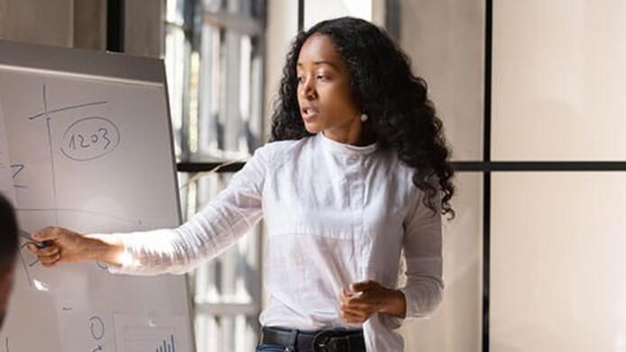 a business analyst woman is presenting her findings to her team.