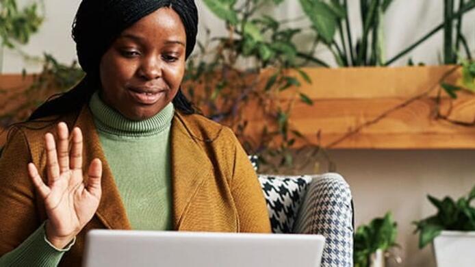 A woman student is sitting at her computer for a virtual counseling session.