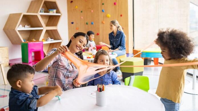elementary students interacting with their female teacher