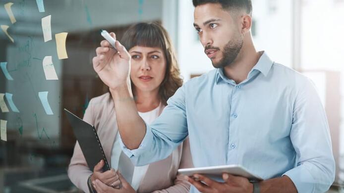 A gentleman and a lady are engaged in a brainstorming session in the office