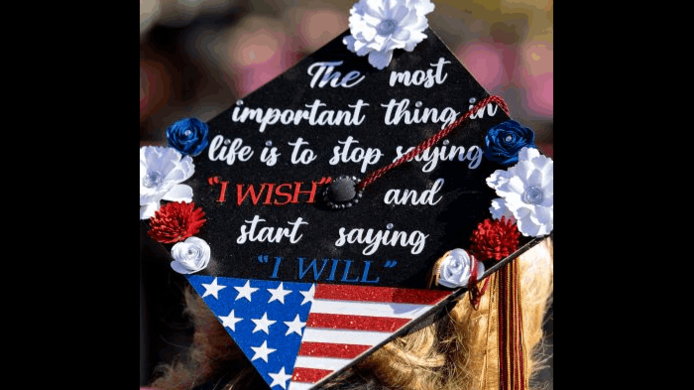 A graduate wearing a graduation cap adorned with red, white, and blue flowers; an image resembling a U.S. flag; and the message The most important thing in life is to stop saying 'I wish' and start saying 'I will.'