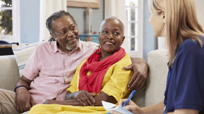 An African-American man and woman meeting with a social worker.