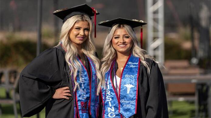 Class of 2022 nursing graduates Sonia and Homa Sher standing next to each other wearing their regalia.