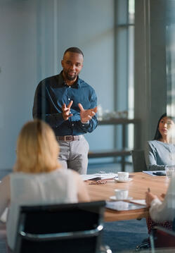 Businessman, meeting and discussion with office, boardroom and collaboration or workshop. Leader, training and presentation for mentor, coaching and strategy for teamwork and planning with startup