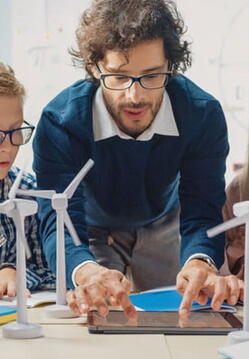 male teacher working with elementary kids on a science project