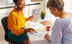 A female nutritionist explaining to her client nutrition facts on product label.