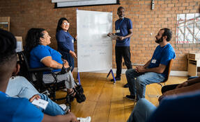 Mature man talking in a meeting at a community center - including a disabled person