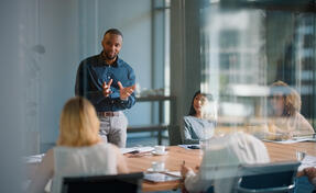 Businessman, meeting and discussion with office, boardroom and collaboration or workshop. Leader, training and presentation for mentor, coaching and strategy for teamwork and planning with startup