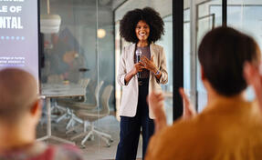 Black woman leading a panel discussion about sustainability in the office