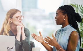 female HR professional in office speaking to a coworker