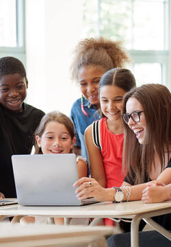 Elementary teacher with students on laptop