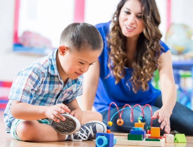 early childhood special education teacher working with a male preschool special needs child