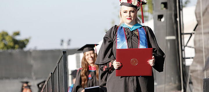 Umass Global Graduate Walking On Stage