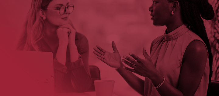 Two diverse businesswomen having a discussion to share ideas and plans while working together in an office