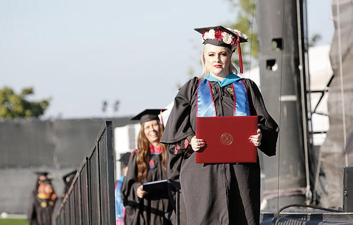 Umass Global Graduate Walking On Stage