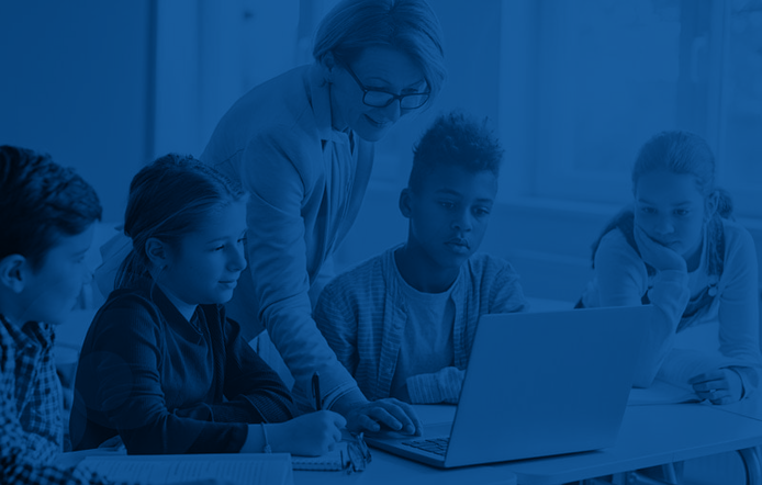 older female teacher who has her credential teaching a group of older elementary school children